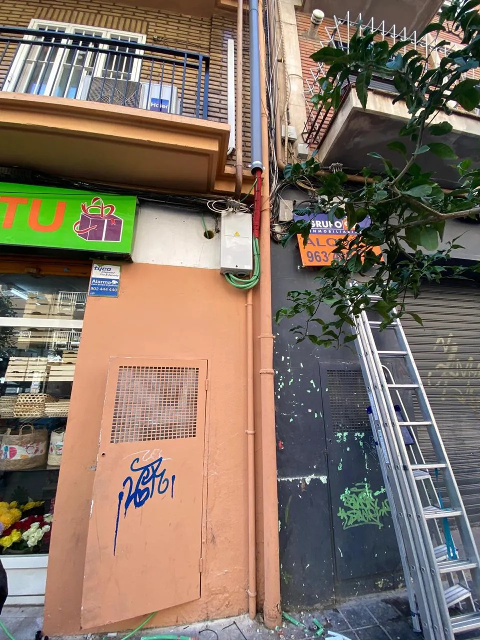 La caja general de protección montada en la fachada, con el tubo rojo de acometida y el cableado recogido