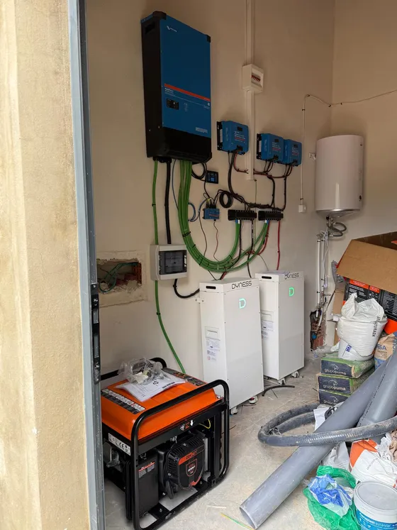 Las dos baterías Dyness, el inversor Victron MultiPlus y el generador de apoyo instalados en el garaje