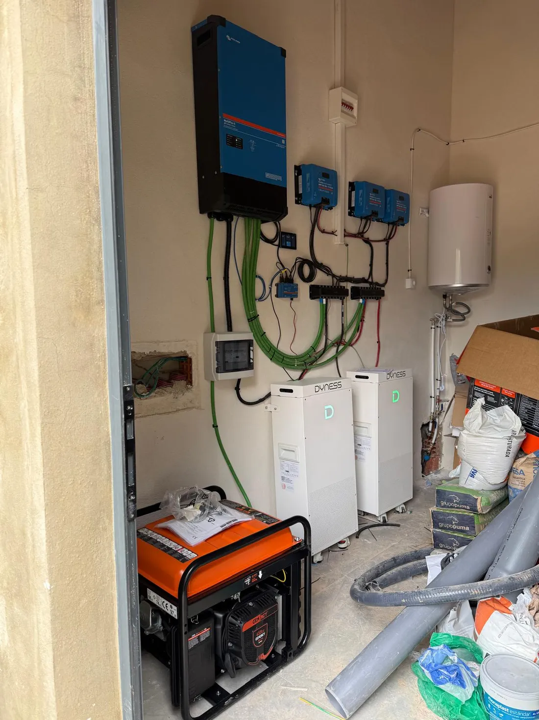 Las dos baterías Dyness, el inversor Victron MultiPlus y el generador de apoyo instalados en el garaje