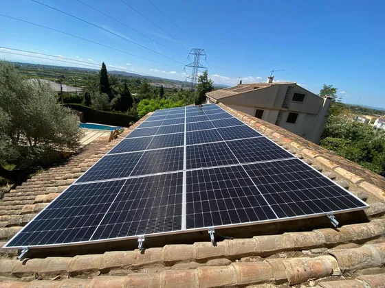 Paneles solares cubriendo el faldón de un tejado de teja en una vivienda con vistas al campo