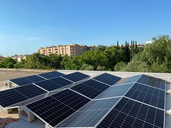 Filas de paneles solares sobre estructura inclinada y bases de hormigón en una cubierta plana
