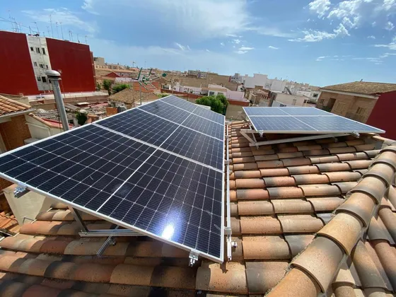 Paneles solares elevados sobre estructura de soporte para corregir la pendiente de un tejado de teja