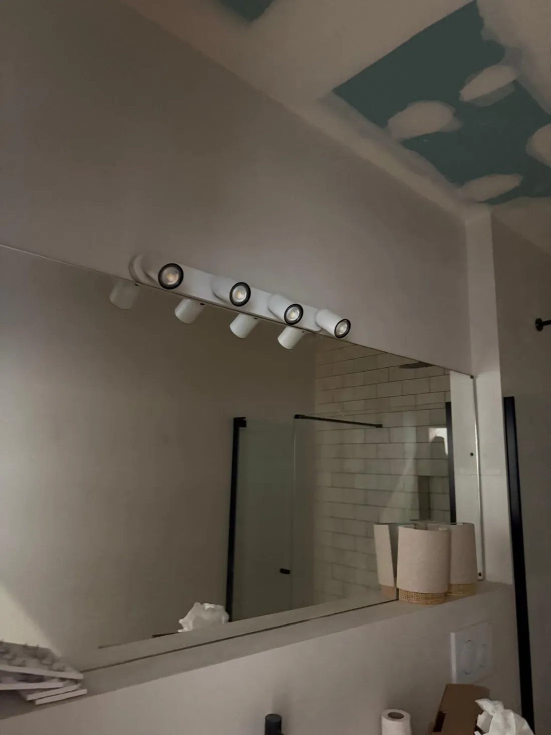 Regleta de cinco focos orientables encendida sobre el espejo del lavabo