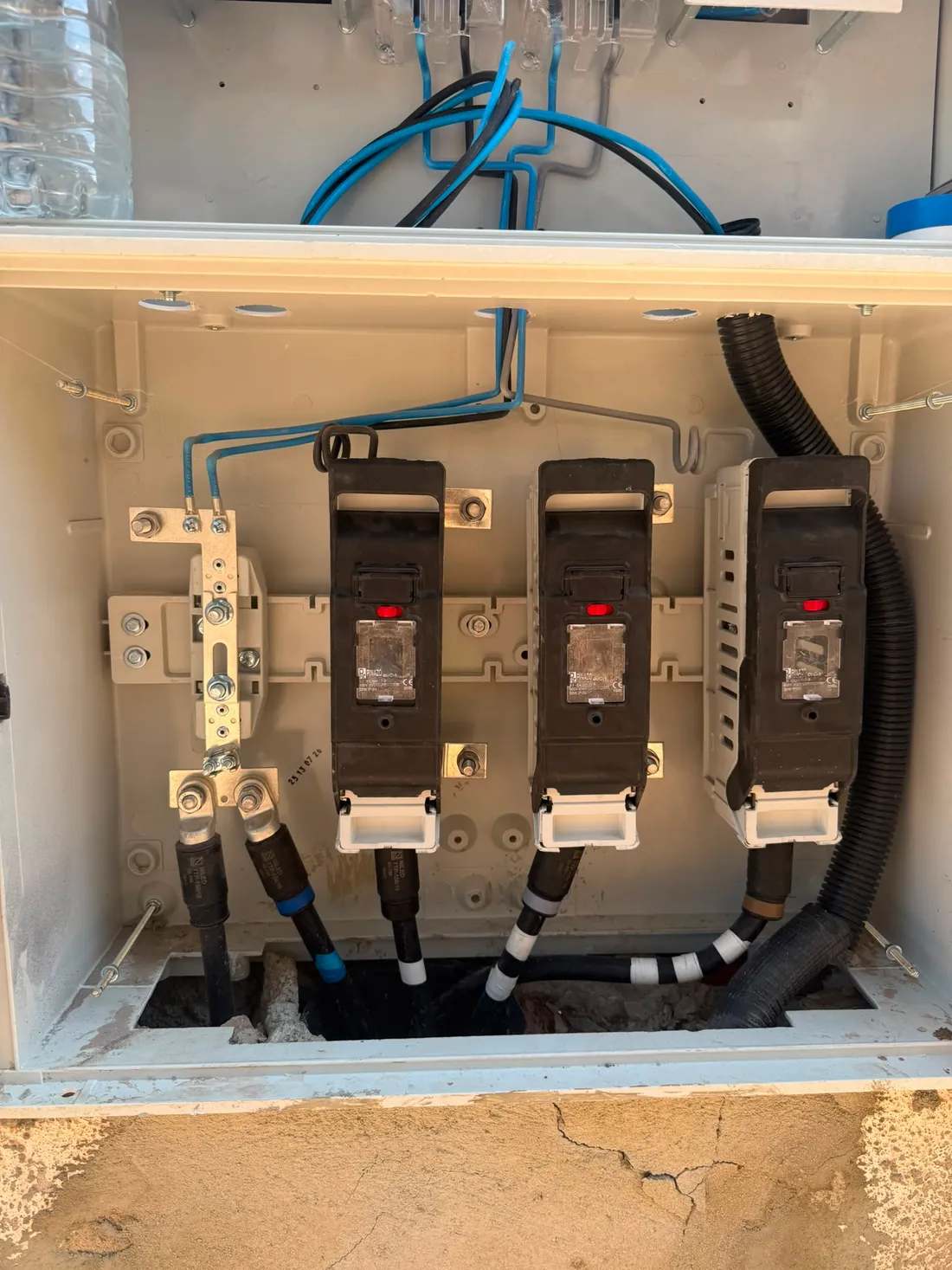 Caja de protección de la acometida abierta, con las tres bases portafusibles y los terminales de entrada