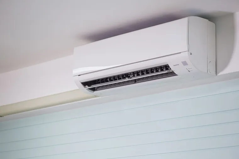 Unidad interior de un equipo de aire acondicionado split instalada en la parte alta de la pared de una vivienda